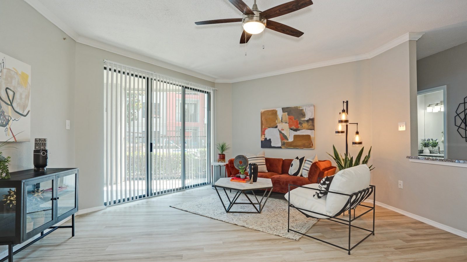 a living room with a ceiling fan and hardwood floors at The  Lana