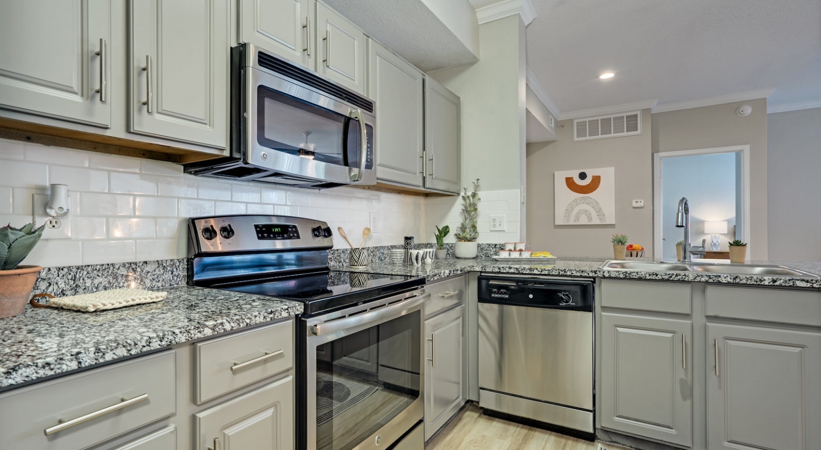 a kitchen with stainless steel appliances and granite counter tops at The Lana