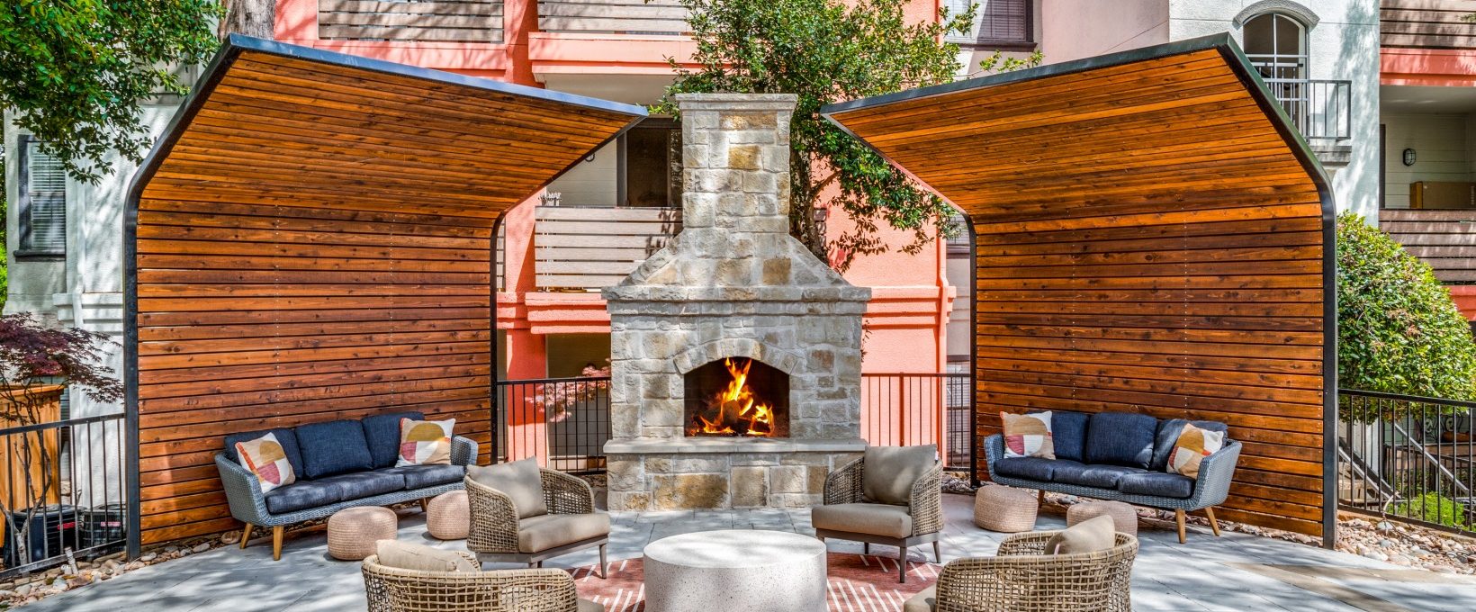 a patio with a fireplace and seating area at The  Lana
